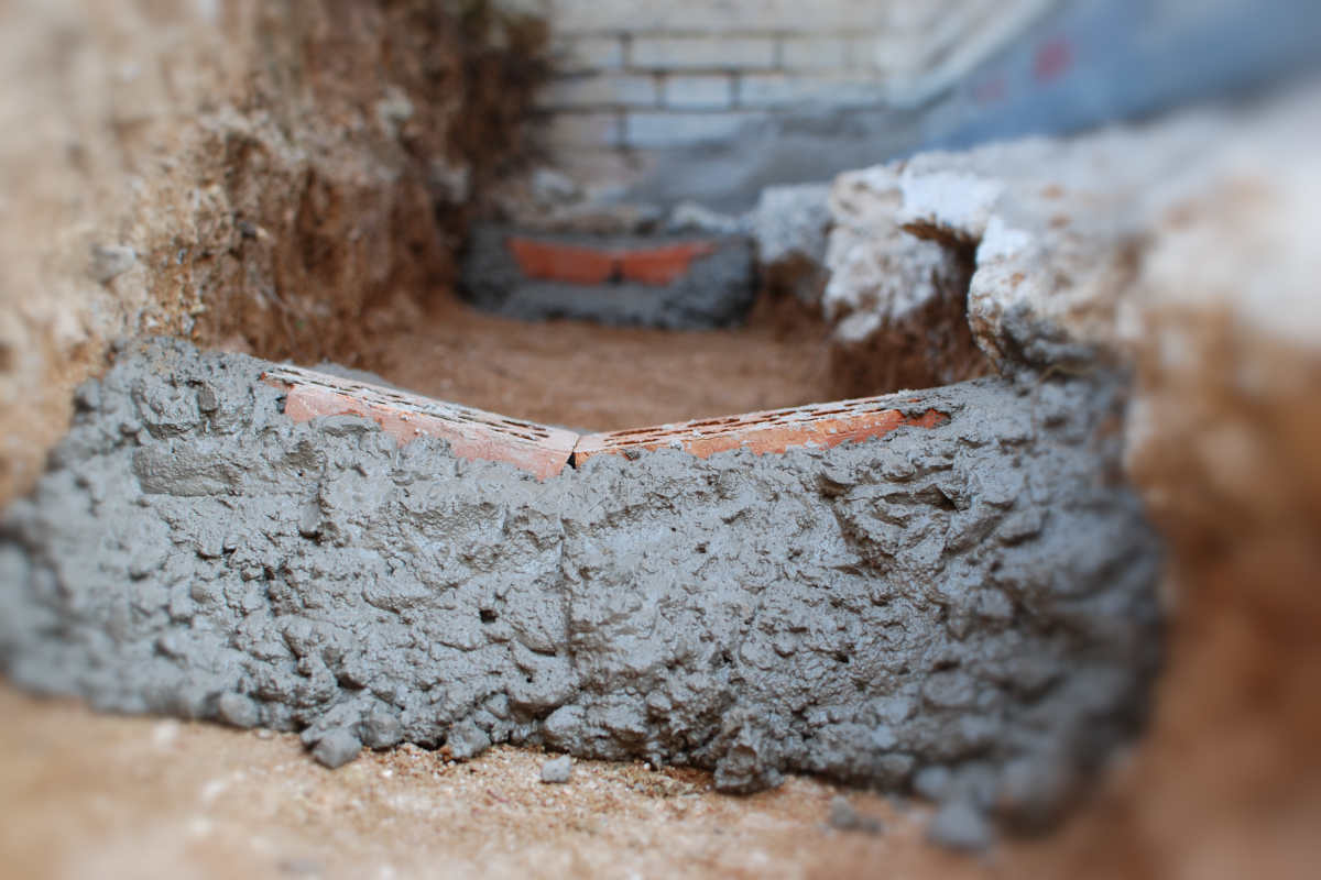 Superficie de concreto con fisuras visibles y signos de deterioro causados por errores en la mezcla y exposición a agentes químicos.